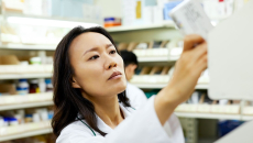 A pharmacist arranging a medicine rack at a pharmacy