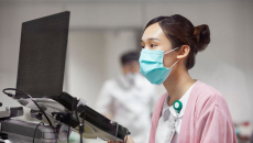 A nurse encoding a patient's record on a laptop
