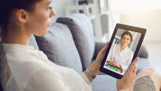 A patient consulting with a doctor online using a digital tablet
