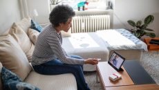 A patient in a virtual consultation with a doctor using a digital tablet