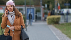 Woman on phone holding mask