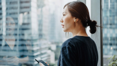 Person with smarphone staring out the window