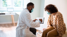 Doctor showing clipboard to patient