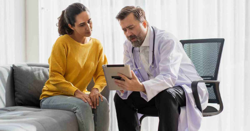 Doctor showing tablet to patient