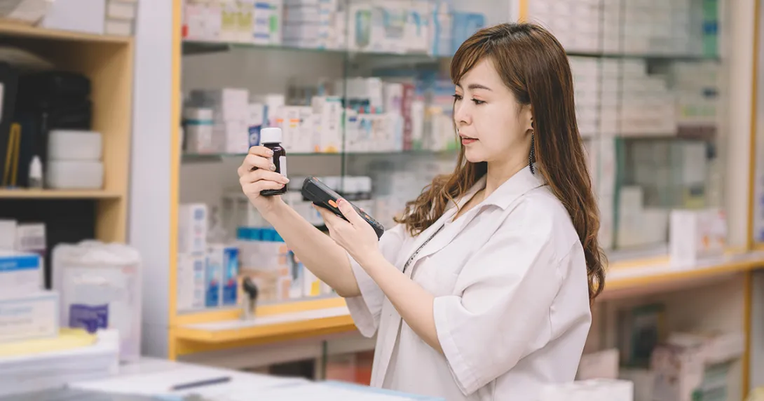 Pharmacist scanning pill bottle