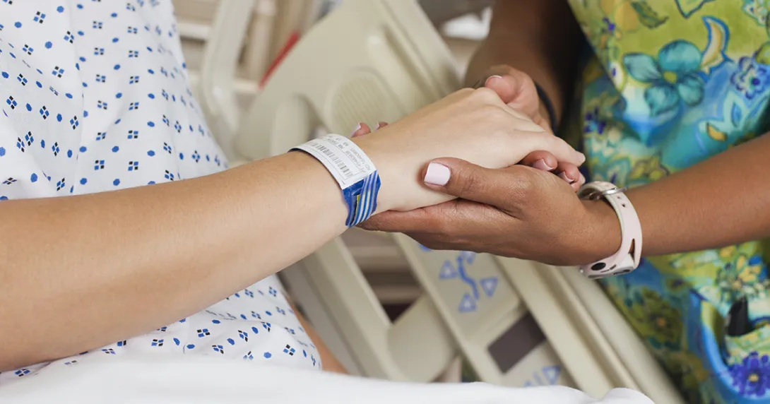 Patient holding healthcare worker's hand