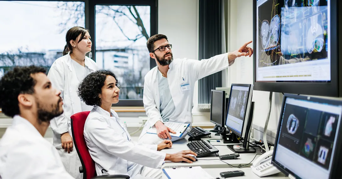 Healthcare workers pointing at a medical image on a display
