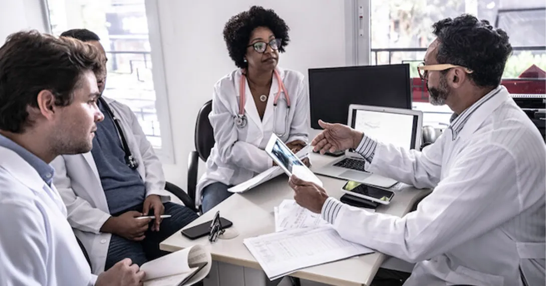 Doctors sitting at a desk and discussing data
