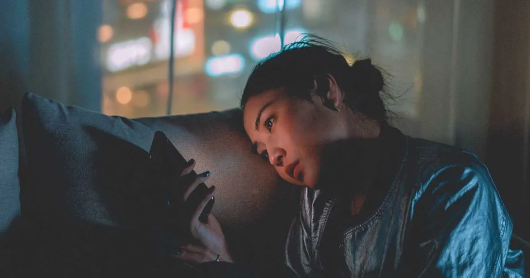 Person with a smartphone on a couch