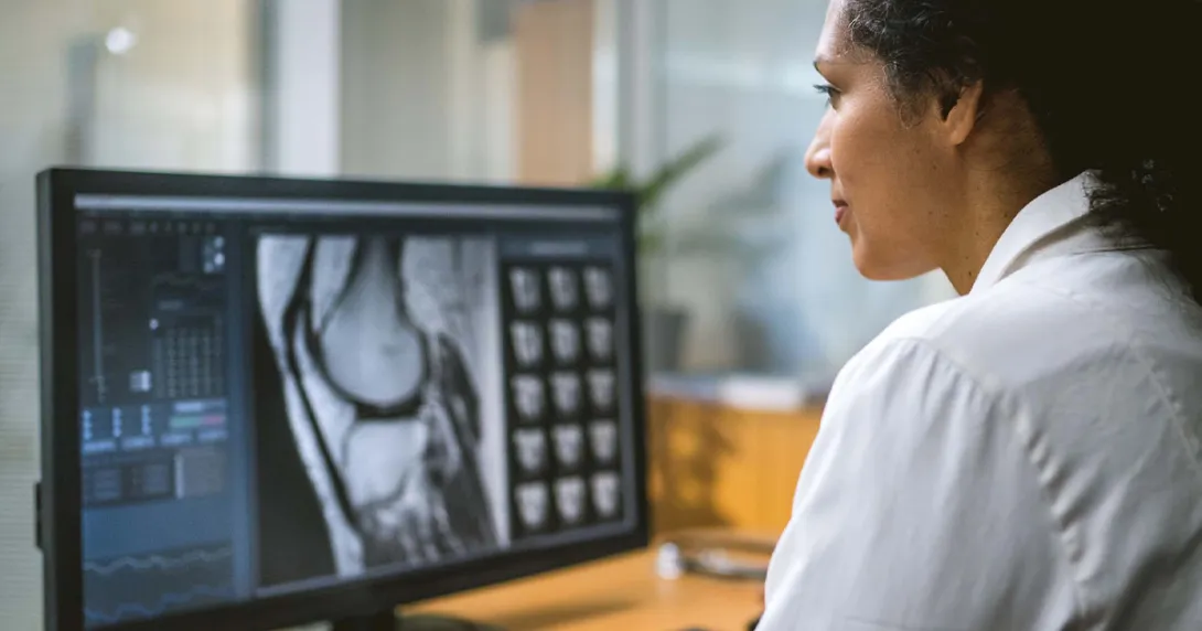 Healthcare worker looking at medical image on computer
