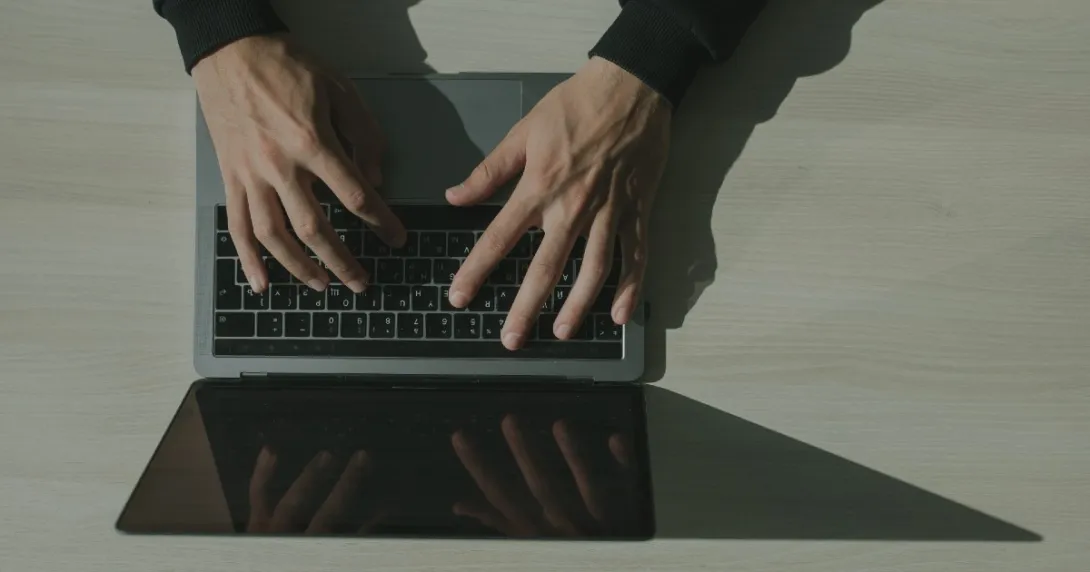 Overhead view of hands working on a laptop