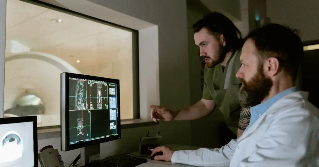 Two people look at diagnostic images on a screen