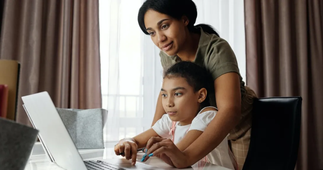 A parent and child look at a computer