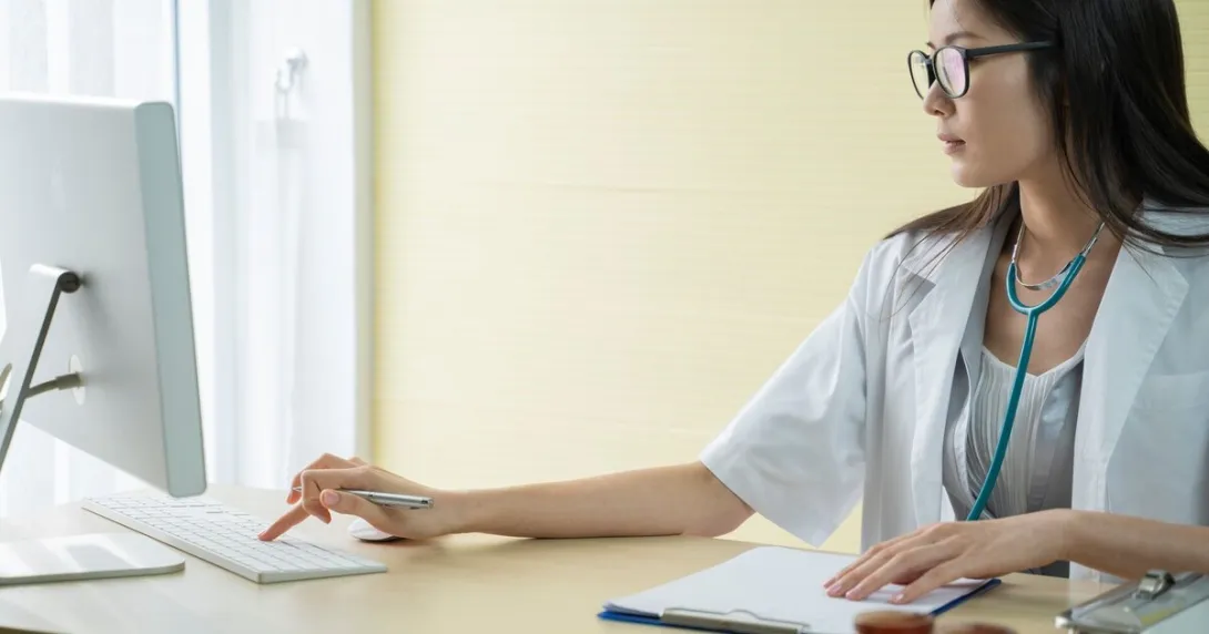 A doctor using a desktop computer