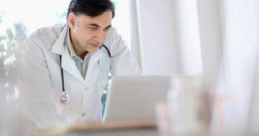 A doctor working on a laptop