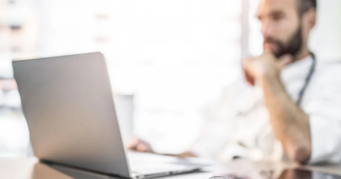 Doctor reviews patient appointments on a laptop