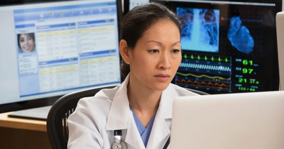 Cardiologist sits at computers