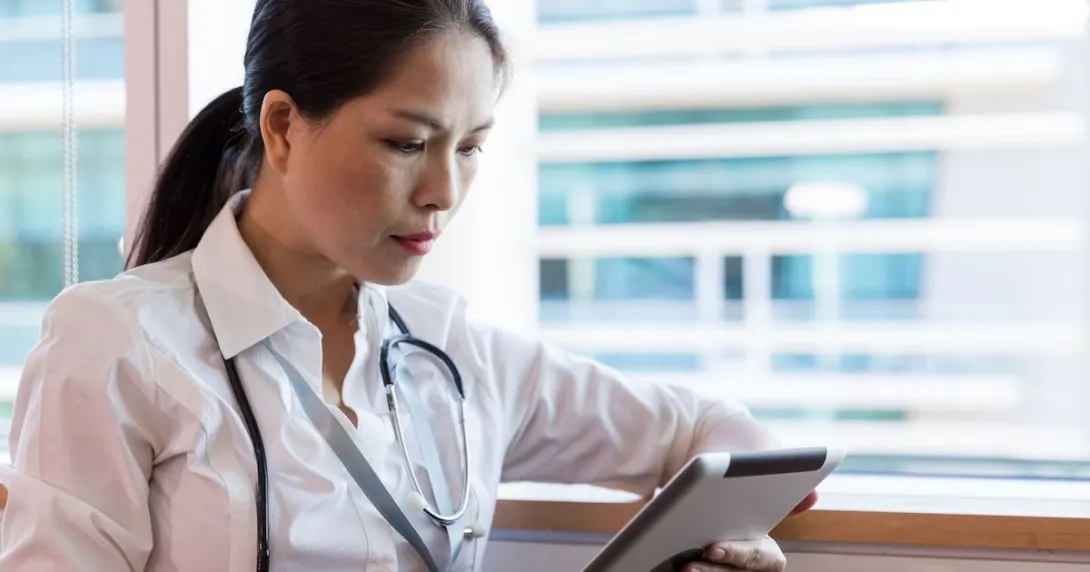 A doctor reading a patient's medical record through a digital tablet
