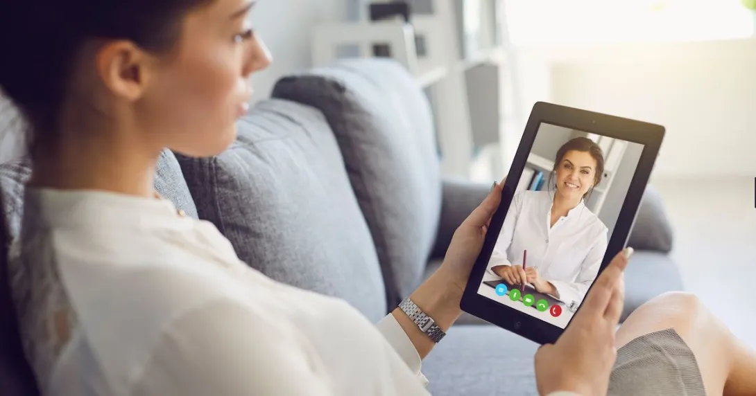 A patient consulting with a doctor online using a digital tablet