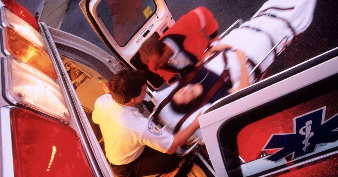 Overhead view of paramedics putting a patient on a stretcher into an ambulance