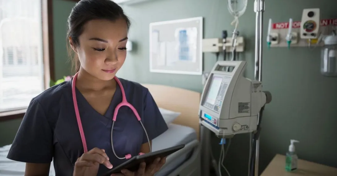 A nurse looking at a digital tablet