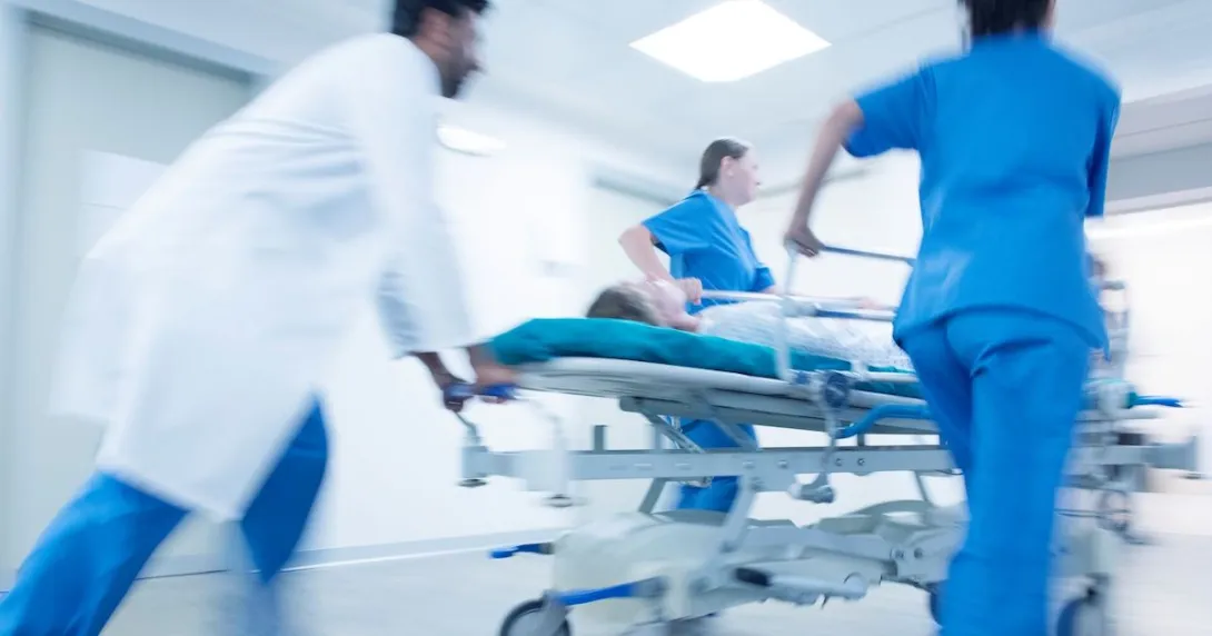 An emergency medical team bringing in a patient on a gurney