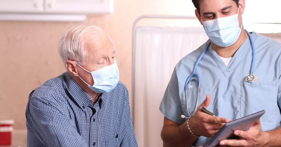 A doctor discussing with a senior patient their test results using a digital tablet