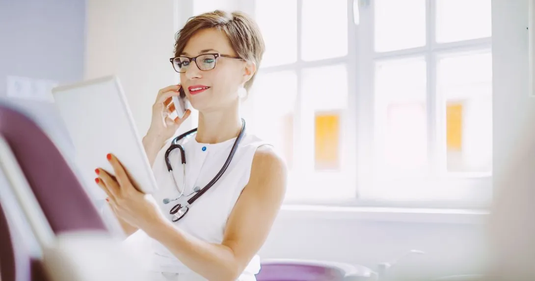 A doctor on a call while checking a patient's digital record