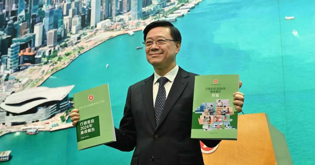 Hong Kong Chief Executive John Lee Ka-chiu holding copies of the 2025 Policy Address