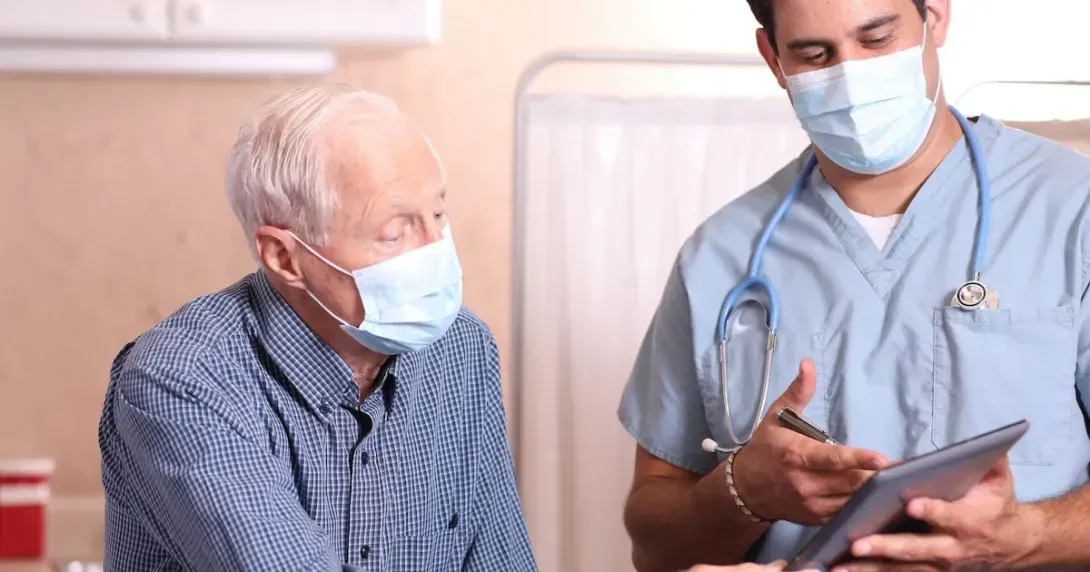 Senior patient reviews information with a doctor during an in-patient visit
