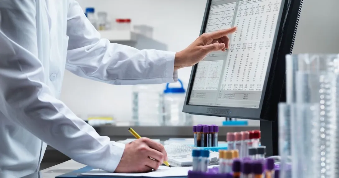 A scientist analysing data from a desktop computer