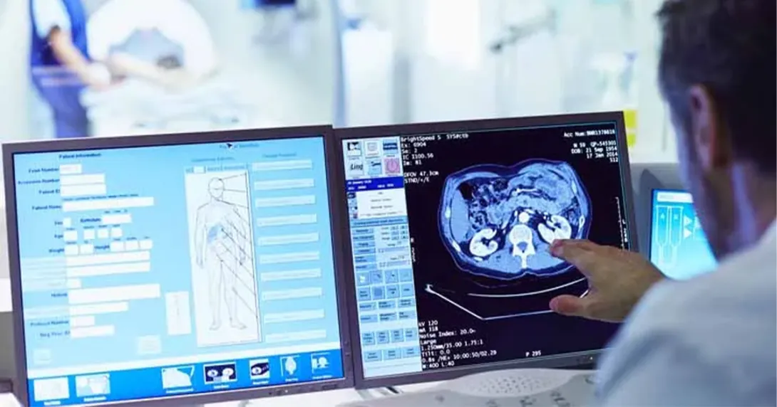 Radiologist looks at images and data on screen during a patient appointment