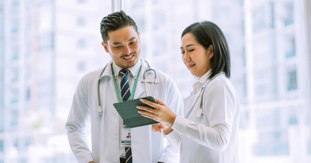 Two doctors discussing a patient's case using a digital tablet