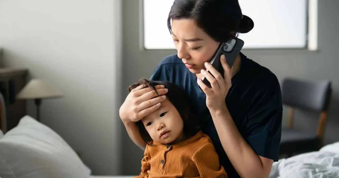 Person holding child talking on the phone