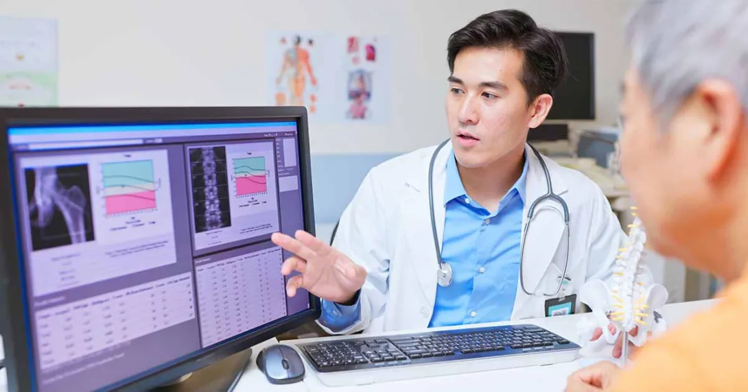 Doctor showing medical images on computer monitor to patient