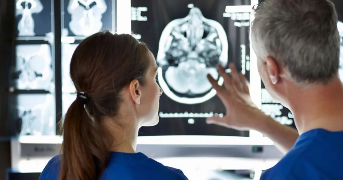 Radiologists review scans on a computer