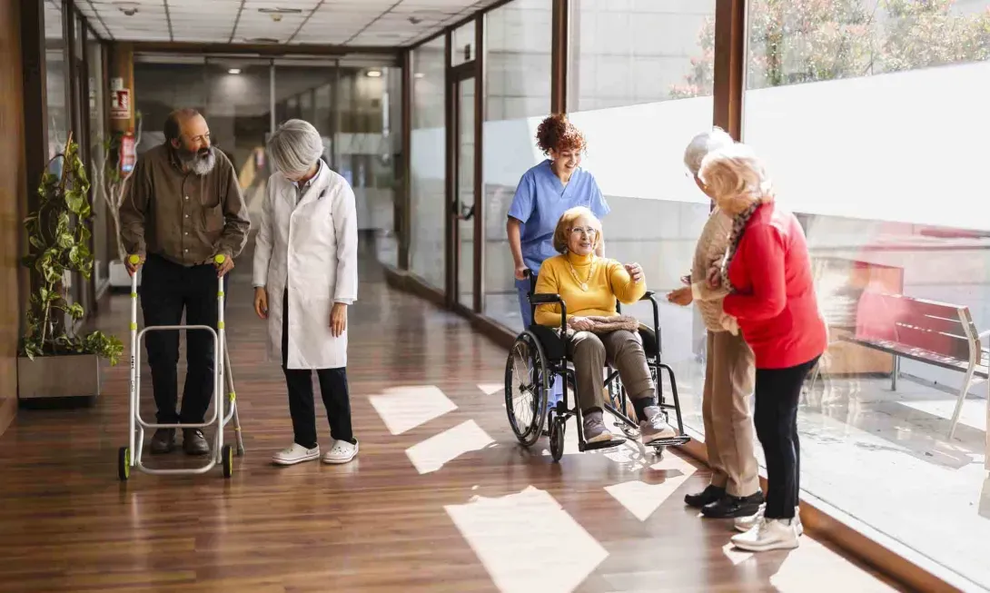 Nurses and post-acute facility patients walk in a hallway