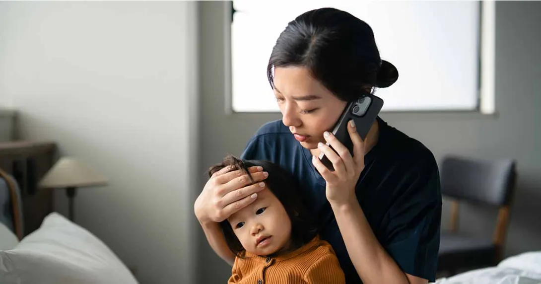 Person holding child while talking on the phone