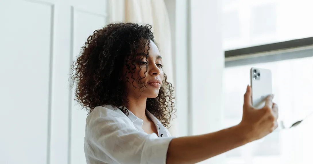 Woman in white shirt takes selfie