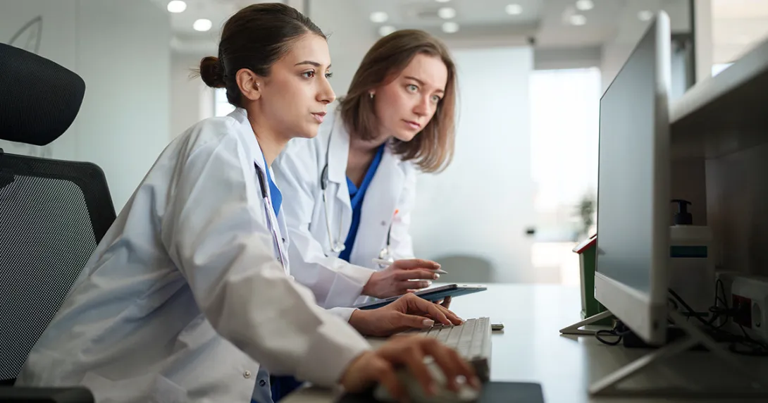 Two healthcare clinicians consult AI data 