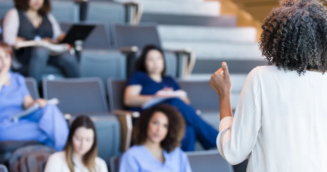 An instructor teaching a class of medical students
