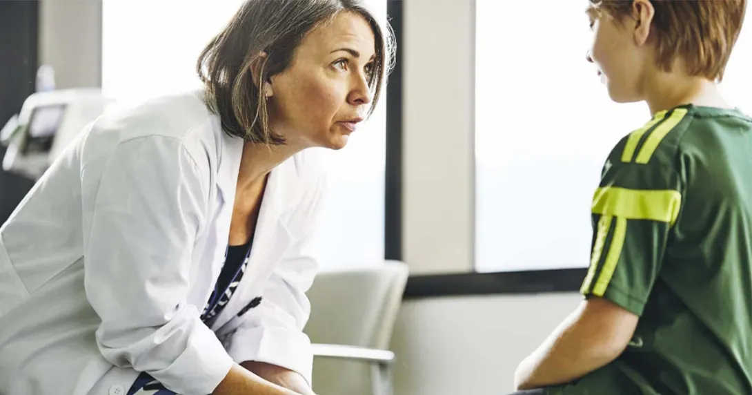 Doctor speaks to child in exam room