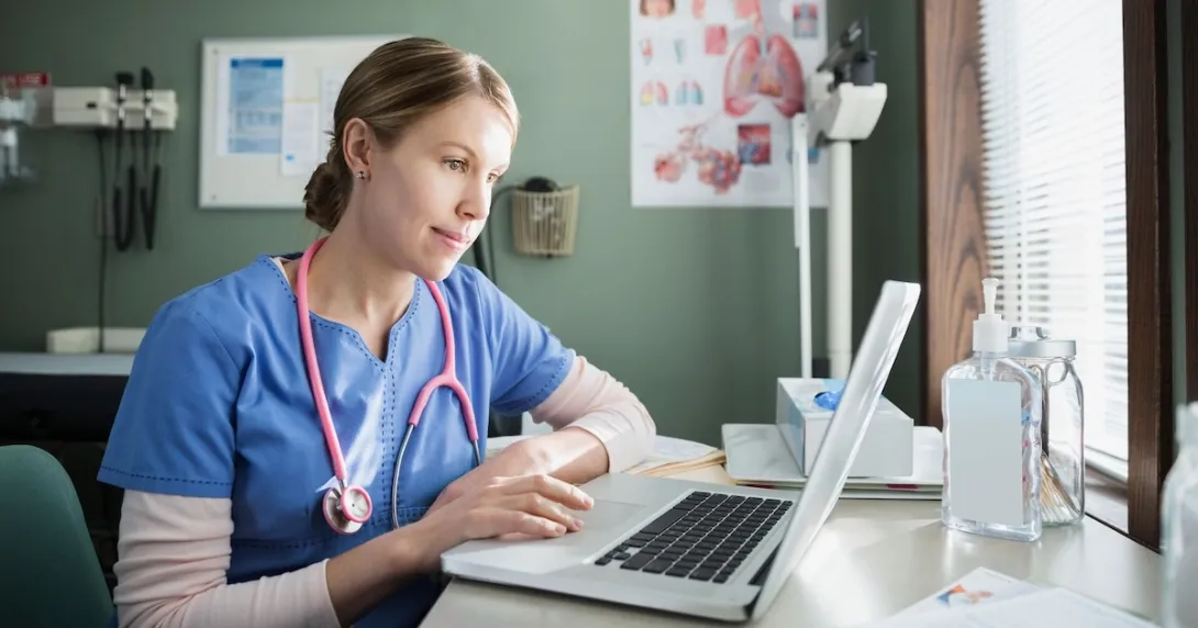A doctor checking a patient's file on a laptop computer
