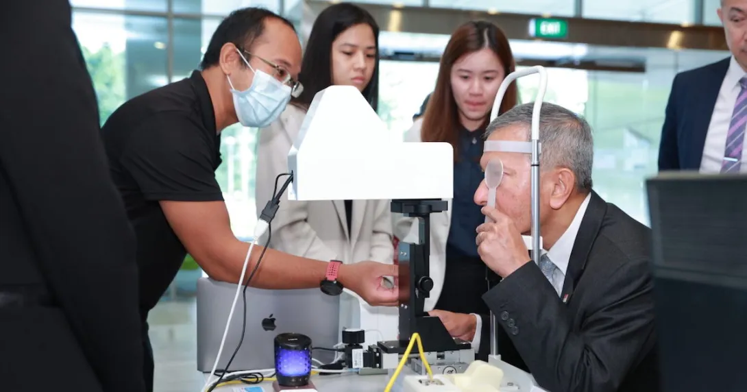 Singaporean Foreign Affairs Minister Dr Vivian Balakrishnan tries out the Automated Visual Acuity Test at the launch event of NUS Medicine's Centre for Innovation and Precision Eye Health.