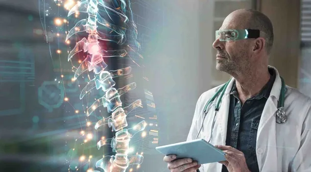 Healthcare worker with tablet looking at a digital display of a human spine