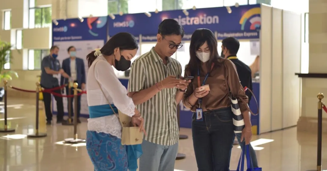 HIMSS22 APAC conference participants looking at their phones.