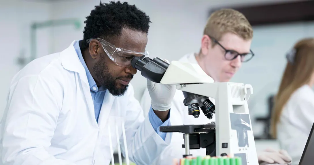 Lab worker looking through microscope