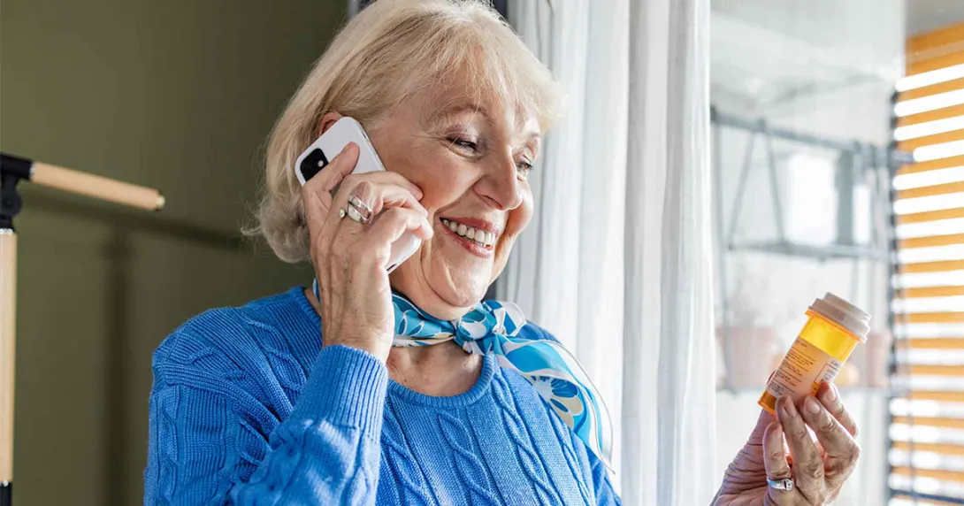 Person on phone holding pill bottle