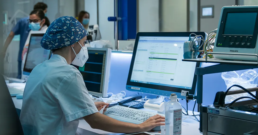 Clinician reviews works at hospital desktop computer