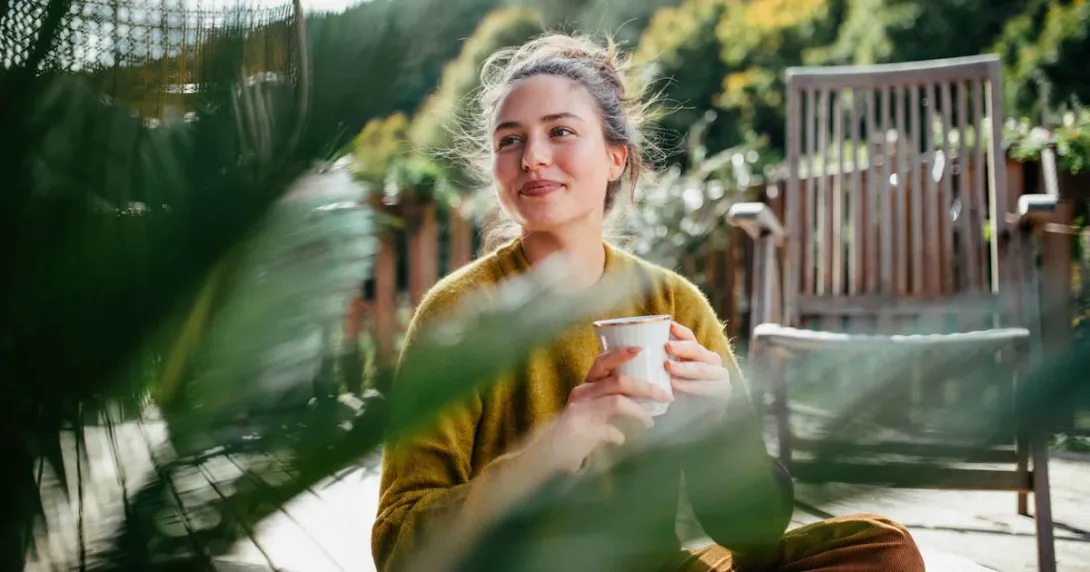 Person holding coffee mug outdoors